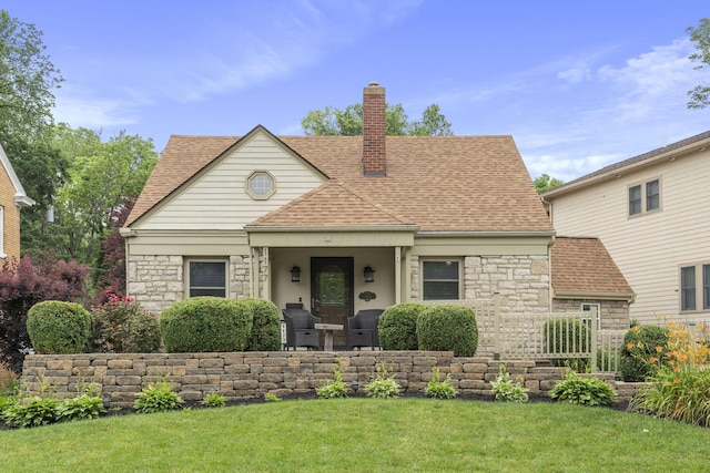 1177 NW Blvd, Columbus, OH 43212 - view of front of house featuring stone siding, a shingled roof, a chimney, and a front yard