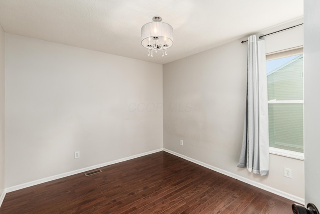 7774 Kingman Pl, Lewis Center, OH 43035 - spare room with dark wood finished floors and a chandelier