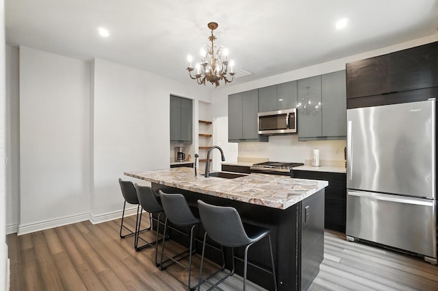 626 S 22nd St, Columbus, OH 43205 - kitchen with appliances with stainless steel finishes, wood finished floors, a kitchen breakfast bar, a kitchen island with sink, and recessed lighting