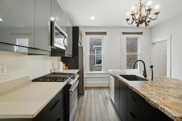 626 S 22nd St, Columbus, OH 43205 - kitchen with appliances with stainless steel finishes, dark cabinetry, wood finished floors, modern cabinets, and recessed lighting