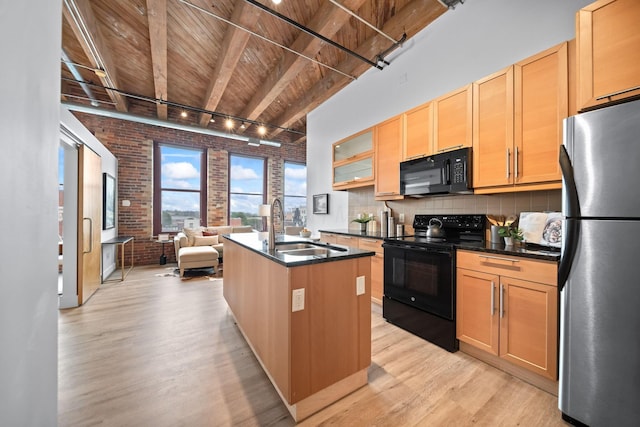 150 E Main St Unit 512, Columbus, OH 43215 - kitchen with black appliances, brick wall, a wood ceiling with exposed beams, light wood finished floors, and open floor plan