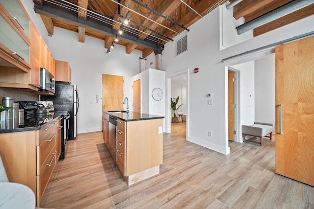 150 E Main St Unit 512, Columbus, OH 43215 - kitchen with a high ceiling, stainless steel microwave, light wood-style flooring, tasteful backsplash, and beamed ceiling