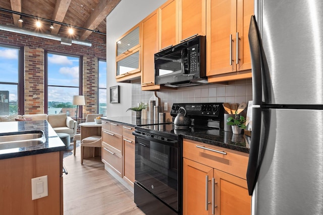 150 E Main St Unit 512, Columbus, OH 43215 - kitchen with black appliances, brick wall, light wood-style floors, tasteful backsplash, and a wooden ceiling with exposed beams