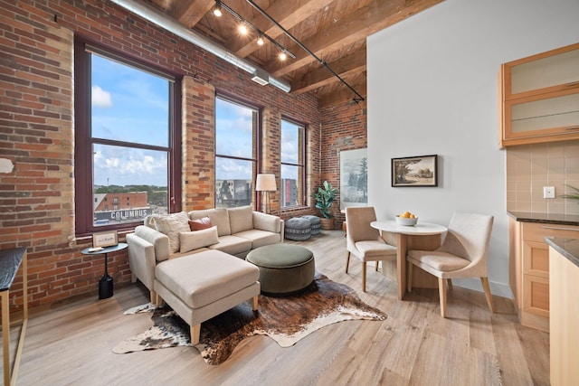 150 E Main St Unit 512, Columbus, OH 43215 - living room with brick wall, a towering ceiling, light wood finished floors, and a wood ceiling with exposed beams