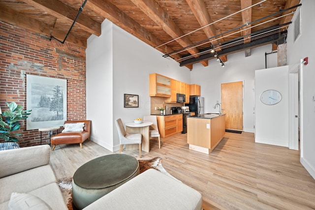 150 E Main St Unit 512, Columbus, OH 43215 - living room with a towering ceiling, light wood finished floors, a wooden ceiling with exposed beams, and brick wall