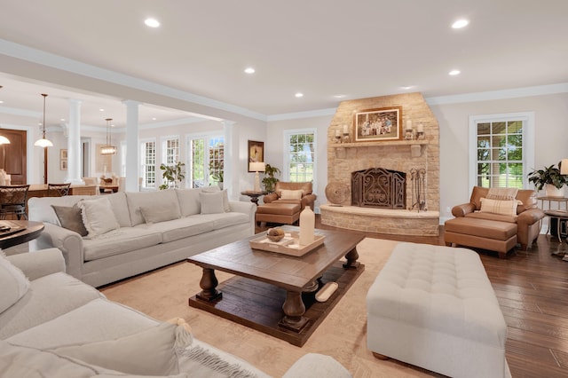 10277 Mackenzie Way, Dublin, OH 43017 - living area with ornamental molding, wood finished floors, decorative columns, recessed lighting, and a stone fireplace