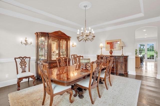 10277 Mackenzie Way, Dublin, OH 43017 - dining space with arched walkways, a raised ceiling, crown molding, a chandelier, and wood finished floors