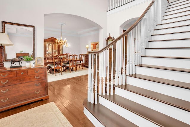 10277 Mackenzie Way, Dublin, OH 43017 - foyer featuring stairs, arched walkways, wood finished floors, a chandelier, and crown molding
