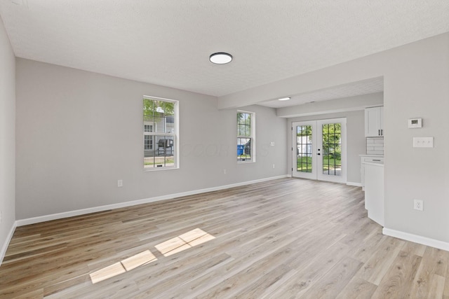 1664 S Champion Ave, Columbus, OH 43207 - empty room featuring french doors, light wood-style flooring, and a textured ceiling