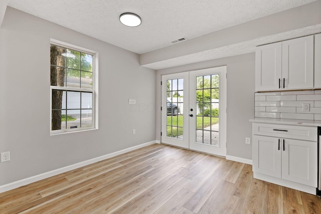 1664 S Champion Ave, Columbus, OH 43207 - unfurnished dining area with french doors, light wood finished floors, plenty of natural light, and a textured ceiling