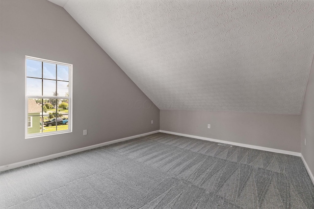 1664 S Champion Ave, Columbus, OH 43207 - additional living space featuring a textured ceiling, dark colored carpet, and vaulted ceiling
