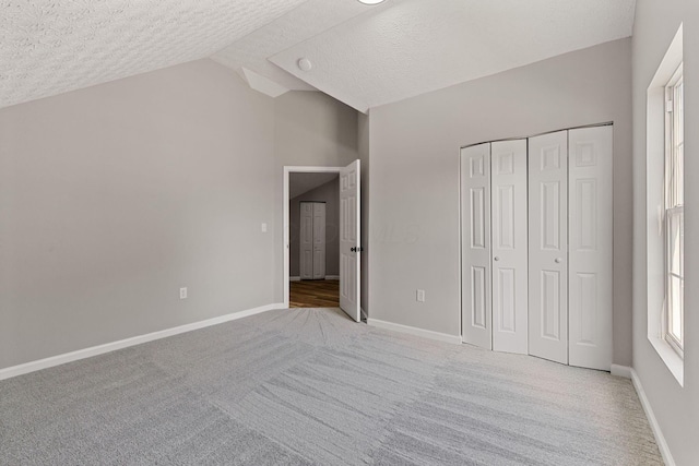 1664 S Champion Ave, Columbus, OH 43207 - unfurnished bedroom with carpet flooring, a textured ceiling, lofted ceiling, and a closet
