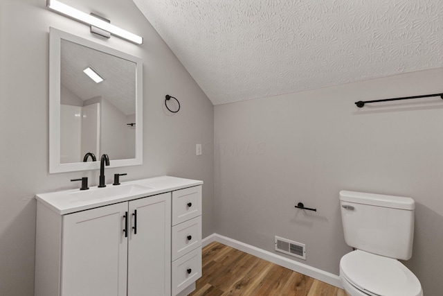 1664 S Champion Ave, Columbus, OH 43207 - bathroom with a textured ceiling, wood finished floors, vanity, and lofted ceiling