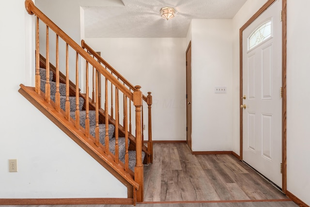 3351 Lindstrom Dr, Columbus, OH 43228 - entryway with wood finished floors, stairway, and a textured ceiling