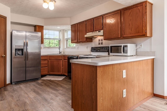 3351 Lindstrom Dr, Columbus, OH 43228 - kitchen with stainless steel refrigerator with ice dispenser, under cabinet range hood, white microwave, black dishwasher, and range with electric cooktop