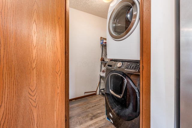 3351 Lindstrom Dr, Columbus, OH 43228 - laundry room with stacked washing machine and dryer, wood finished floors, and a textured ceiling
