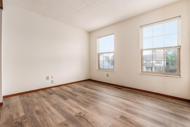 3351 Lindstrom Dr, Columbus, OH 43228 - empty room featuring healthy amount of natural light, wood finished floors, and a textured ceiling