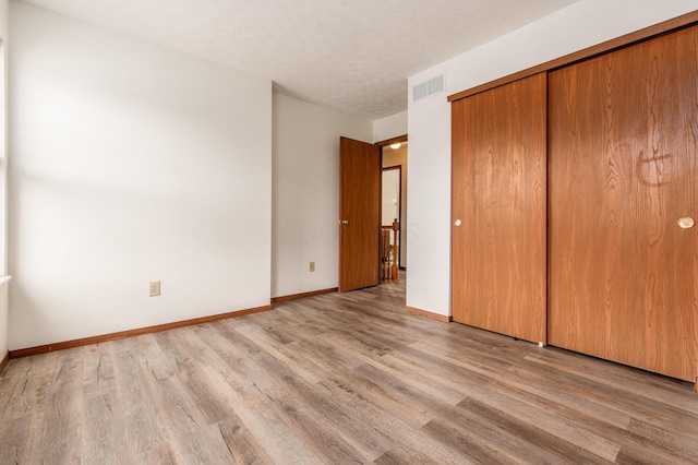 3351 Lindstrom Dr, Columbus, OH 43228 - unfurnished bedroom with wood finished floors, a closet, and a textured ceiling