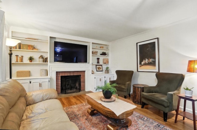 2620 Edgevale Rd, Columbus, OH 43221 - living area with light wood-style flooring, a brick fireplace, built in shelves, and ornamental molding