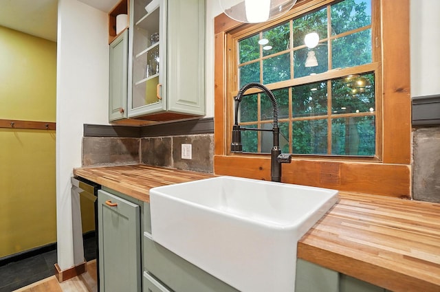 2620 Edgevale Rd, Columbus, OH 43221 - kitchen featuring butcher block countertops, backsplash, glass insert cabinets, and wood finished floors