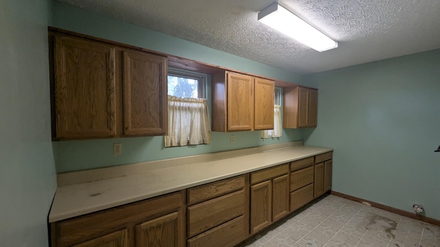 708 Fairview Ave, Galion, OH 44833 - kitchen with a textured ceiling, light countertops, and brown cabinets