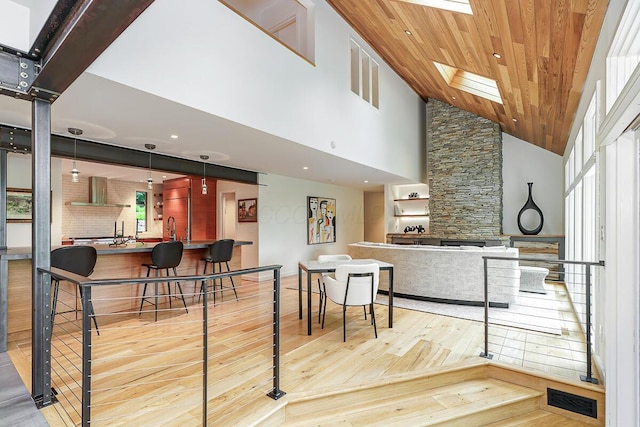 150 Pinehurst Dr, Granville, OH 43023 - kitchen featuring wood-type flooring, high vaulted ceiling, wall chimney range hood, wood ceiling, and open floor plan