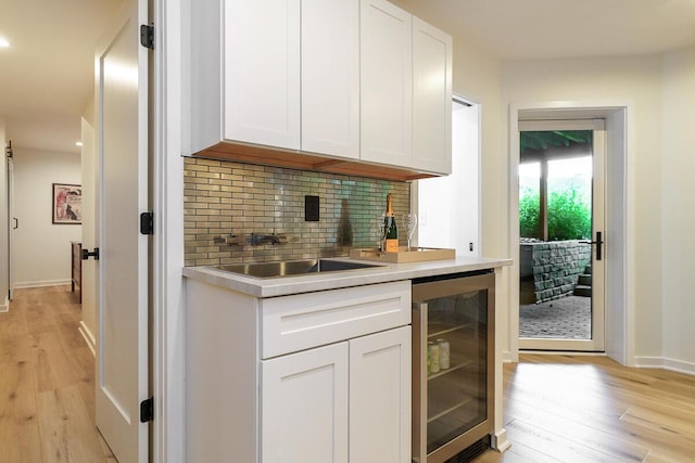 150 Pinehurst Dr, Granville, OH 43023 - kitchen with beverage cooler, stainless steel counters, white cabinetry, light wood-style flooring, and recessed lighting