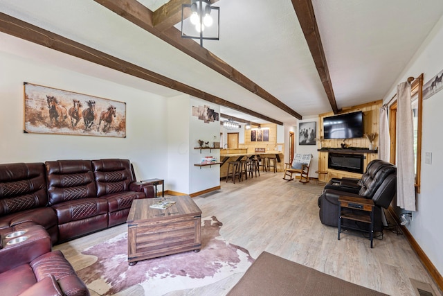 63775 State Route 56, Creola, OH 45622 - living room featuring beamed ceiling, wood finished floors, and a glass covered fireplace