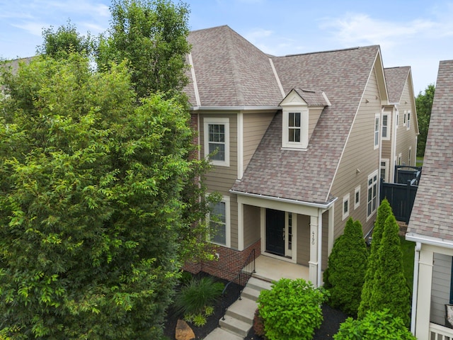 4190 Troutbrook Dr Unit 128, Dublin, OH 43017 - view of front of house featuring a shingled roof, covered porch, and brick siding