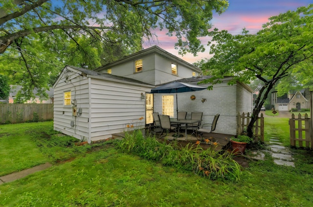2909 Bryden Rd, Columbus, OH 43209 - back of property at dusk featuring an outbuilding, outdoor dining area, and brick siding
