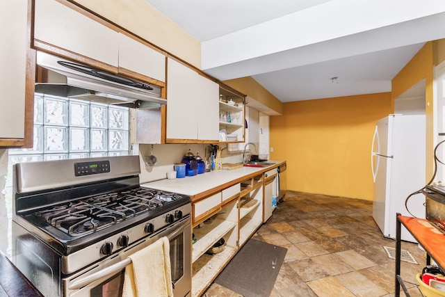 2909 Bryden Rd, Columbus, OH 43209 - kitchen featuring stainless steel range with gas cooktop, under cabinet range hood, white cabinetry, freestanding refrigerator, and open shelves