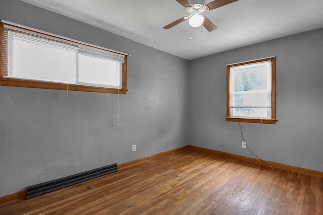 824 Colonial Dr, Heath, OH 43056 - empty room with baseboard heating, wood-type flooring, and ceiling fan