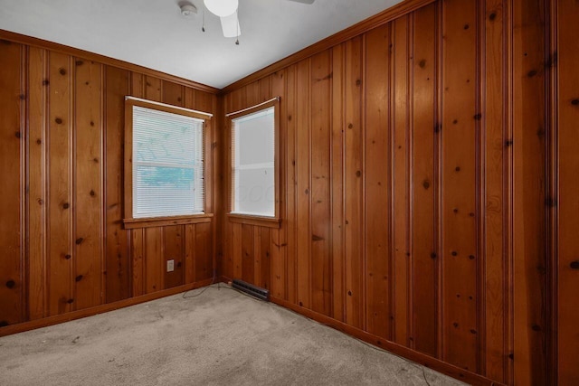 824 Colonial Dr, Heath, OH 43056 - empty room featuring light colored carpet, wooden walls, ceiling fan, and a smoke detector