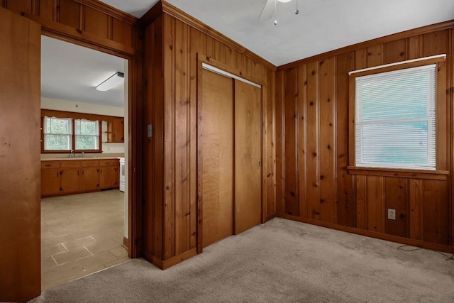 824 Colonial Dr, Heath, OH 43056 - unfurnished bedroom featuring wooden walls, a closet, a ceiling fan, and light colored carpet