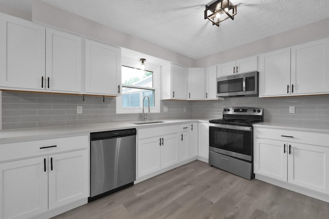 251 Florence Dr, Pickerington, OH 43147 - kitchen featuring stainless steel appliances, a textured ceiling, light countertops, light wood finished floors, and white cabinets