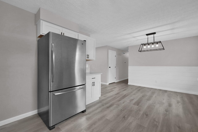 251 Florence Dr, Pickerington, OH 43147 - kitchen with freestanding refrigerator, white cabinets, light wood-type flooring, a textured ceiling, and light countertops