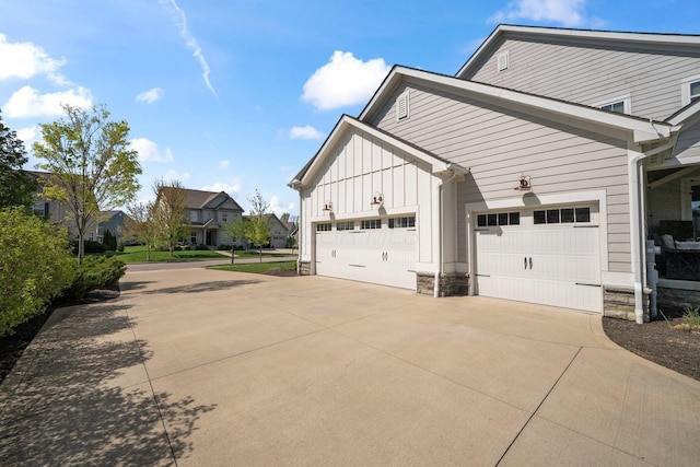 10640 Honeysuckle Way, Plain City, OH 43064 - view of home's exterior featuring driveway, board and batten siding, a garage, stone siding, and a residential view