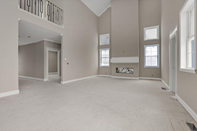 3699 Kassidy Dr, Grove City, OH 43123 - unfurnished living room featuring a towering ceiling, healthy amount of natural light, and crown molding
