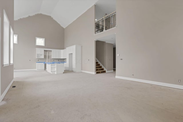 3699 Kassidy Dr, Grove City, OH 43123 - unfurnished living room with high vaulted ceiling, stairs, and light carpet