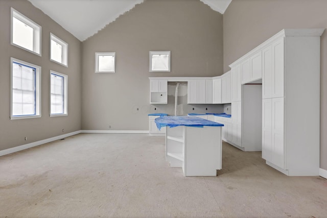 3699 Kassidy Dr, Grove City, OH 43123 - kitchen with high vaulted ceiling, light carpet, a center island, open shelves, and white cabinets