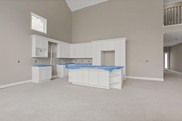3699 Kassidy Dr, Grove City, OH 43123 - kitchen featuring high vaulted ceiling, light carpet, white cabinets, a center island, and open shelves