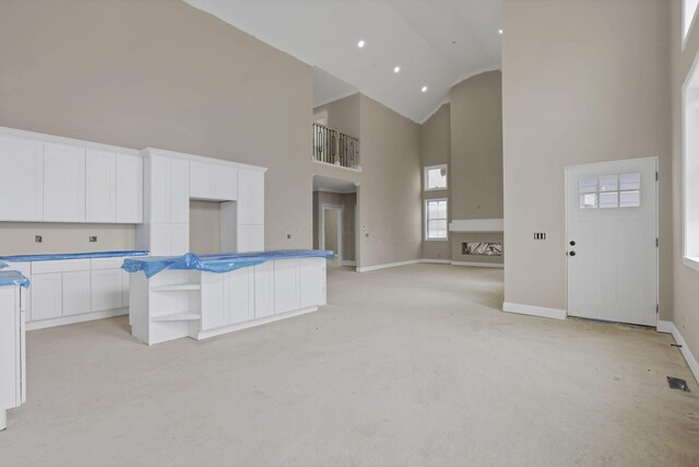 3699 Kassidy Dr, Grove City, OH 43123 - kitchen featuring high vaulted ceiling, light carpet, white cabinets, a kitchen island, and open shelves