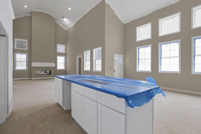 3699 Kassidy Dr, Grove City, OH 43123 - kitchen with high vaulted ceiling, light colored carpet, white cabinetry, open floor plan, and plenty of natural light
