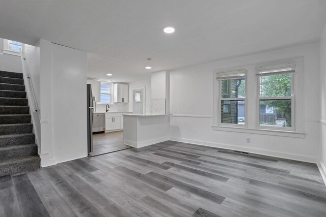 794 E Deshler Ave, Columbus, OH 43206 - unfurnished living room featuring stairway, wood finished floors, and recessed lighting