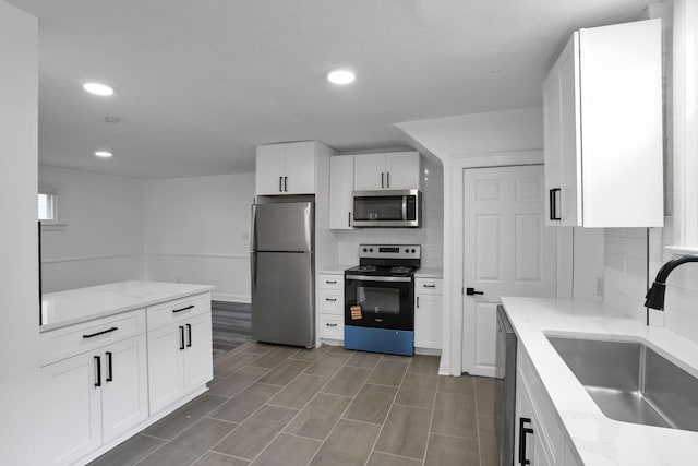 794 E Deshler Ave, Columbus, OH 43206 - kitchen with stainless steel appliances, backsplash, white cabinets, recessed lighting, and light stone countertops
