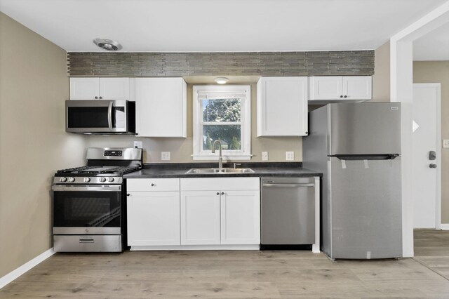 678 E Fair Ave, Lancaster, OH 43130 - kitchen with appliances with stainless steel finishes, dark countertops, white cabinets, and light wood-style floors