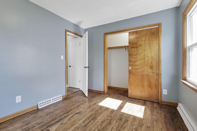 678 E Fair Ave, Lancaster, OH 43130 - unfurnished bedroom featuring baseboard heating, wood finished floors, multiple windows, and a closet