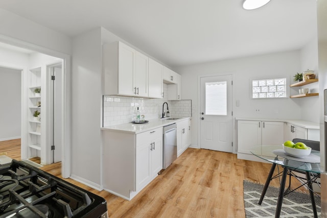 2203 Belcher Dr, Columbus, OH 43224 - kitchen with stainless steel dishwasher, gas range, light wood-style flooring, and light countertops