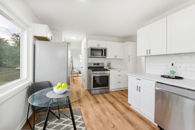 2203 Belcher Dr, Columbus, OH 43224 - kitchen with stainless steel appliances, light wood-type flooring, light countertops, and tasteful backsplash