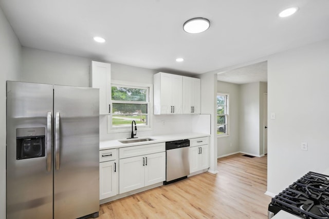 1358 Moler Rd, Columbus, OH 43207 - kitchen with appliances with stainless steel finishes, light countertops, plenty of natural light, white cabinetry, and recessed lighting